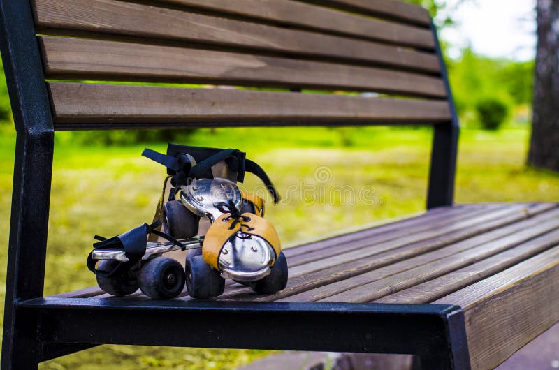 Paia di vecchio pattino di rullo che appende sul banco Sport per tutte le volte fotografia stock Paia di vecchio pattino di rullo che appende sul banco Sport per tutte le volte fotografia stock