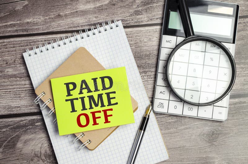 Paid Time Off Wording on a Green Sticker and Notepad Stock Photo