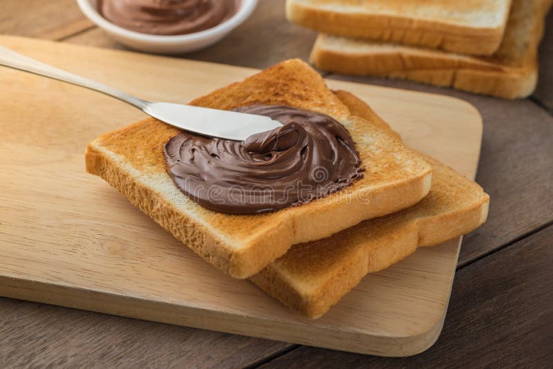 Pain avec de la crème de chocolat du plat en bois photos stock Pain avec de la crème de chocolat du plat en bois photos stock