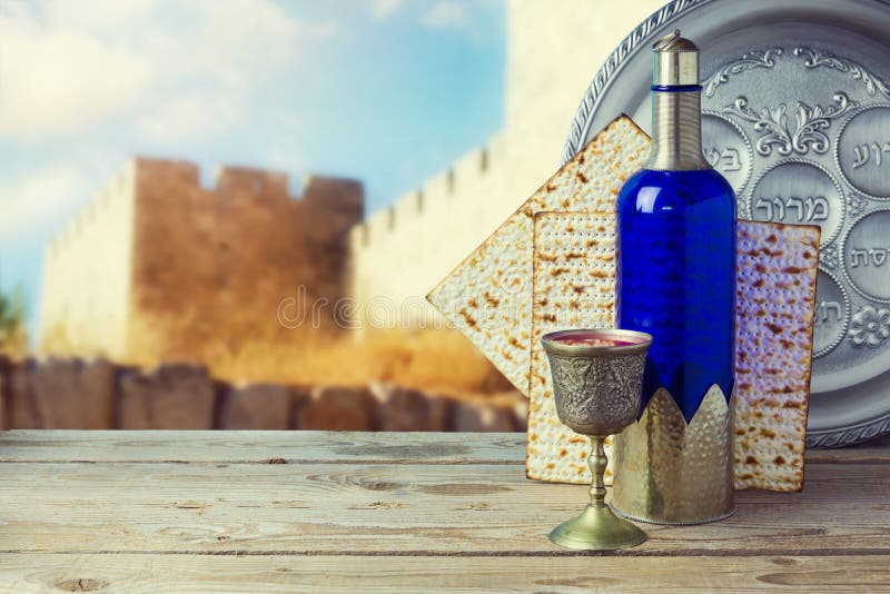Pain azyme et vin de pâque sur la table en bois de vintage au-dessus de vieux murs de ville Plat de Seder avec le texte hébreu photographie stock libre de droits Pain azyme et vin de pâque sur la table en bois de vintage au-dessus de vieux murs de ville Plat de Seder avec le texte hébreu photographie stock libre de droits