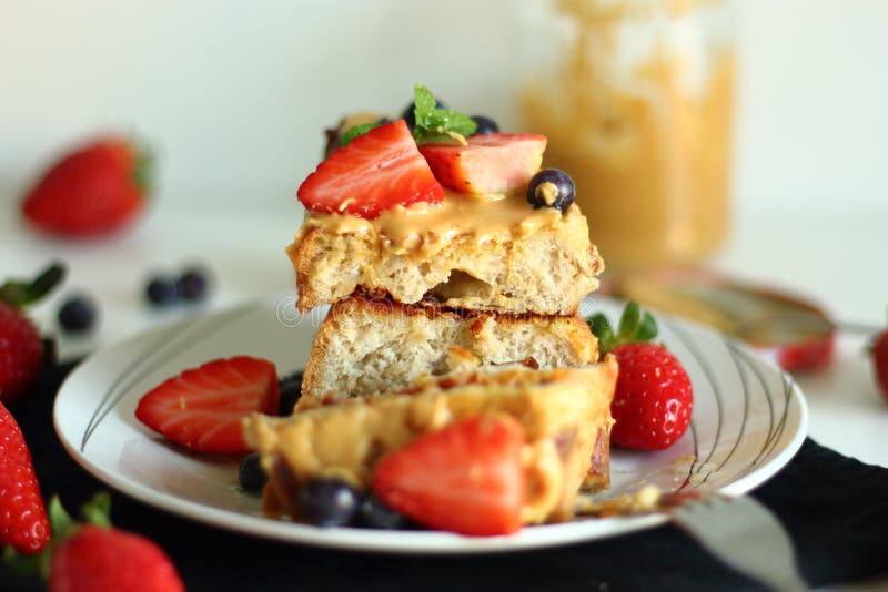 Pain grillé français avec des fraises, des myrtilles et le beurre d'arachide images stock Pain grillé français avec des fraises, des myrtilles et le beurre d'arachide images stock