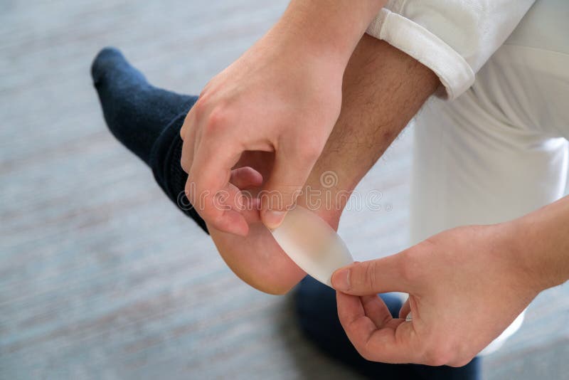 Painful Heel wound on mans feet caused by new shoes. mans hands royalty free stock images Painful Heel wound on mans feet caused by new shoes. mans hands royalty free stock images