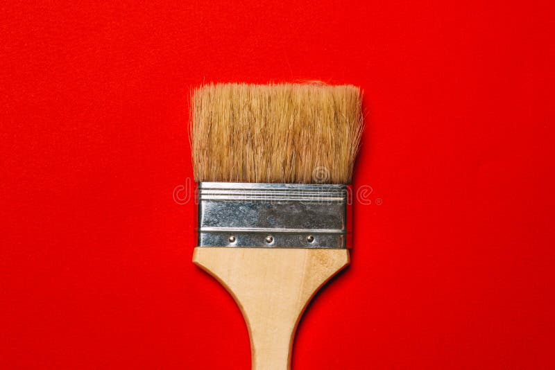 Paint brush on red background top view, abstract minimalism