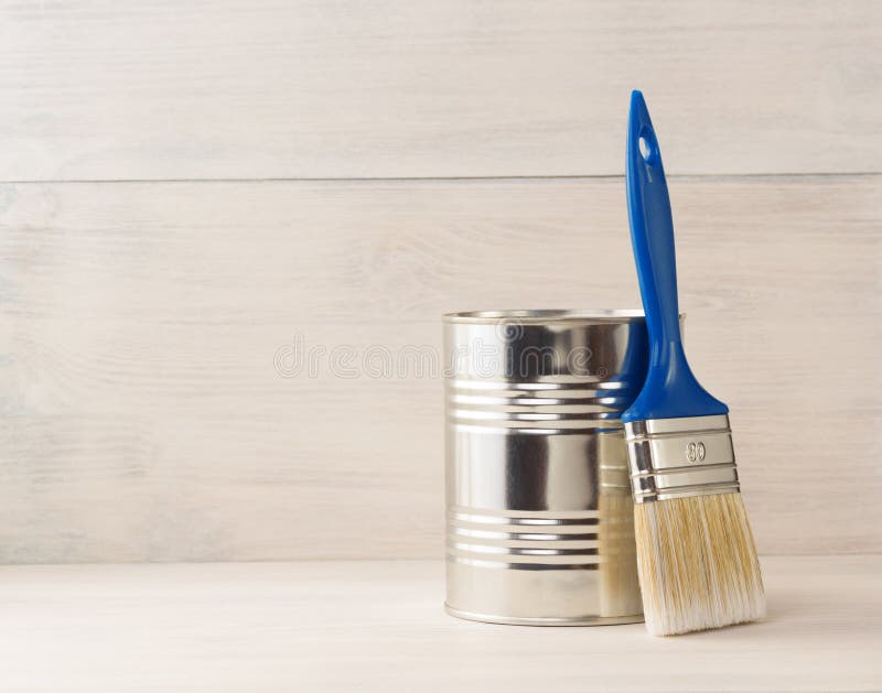 Paint bucket and paintbrush on wood