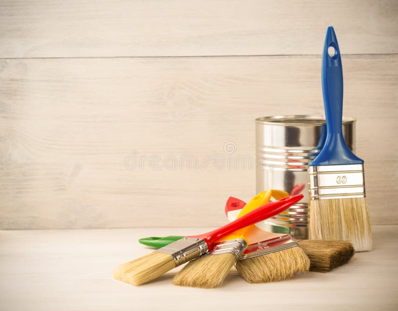 Paint bucket and paintbrush on wood