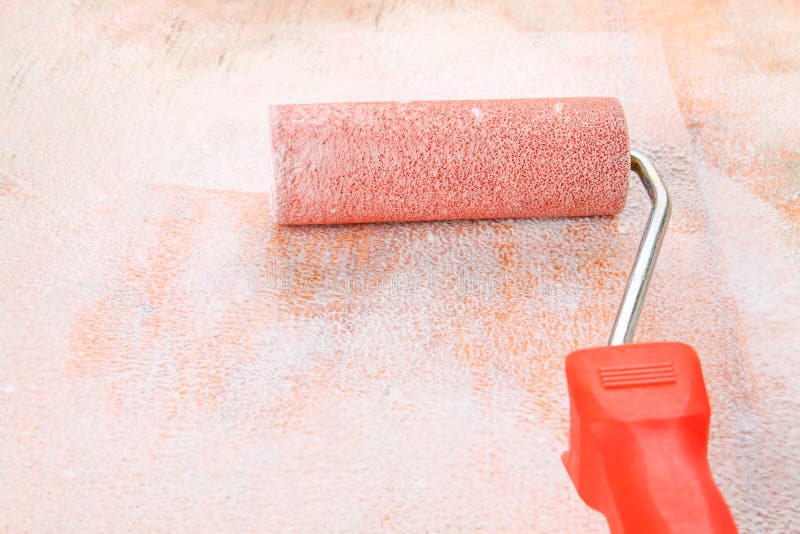 Paint Roll Brush in White Paint on Plywood Surface. Stock Photo Image