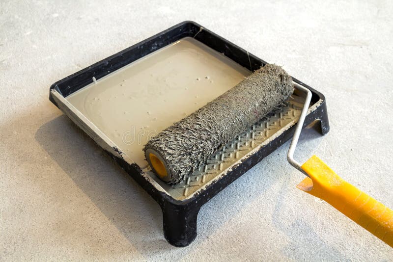 Paint Roller in Paint Tray with Grey Color in the Tray Stock Photo
