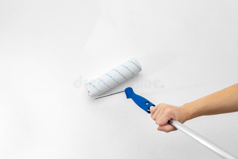 A Paint Roller with White Paint on the Background of a Textured White