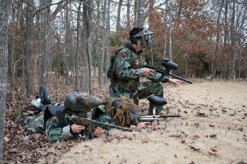 Three kids outside playing paintball in winter. Three kids outside playing paintball in winter.