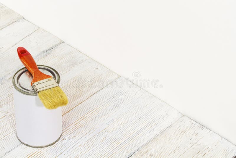 Paintbrush and can, paint brush and white color on wooden floor