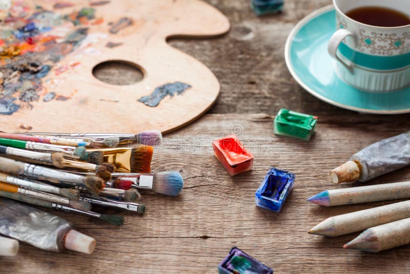 Paintbrushes, палитра художника, карандаши, кофейная чашка и краски стоковые фото Paintbrushes, палитра художника, карандаши, кофейная чашка и краски стоковые фото