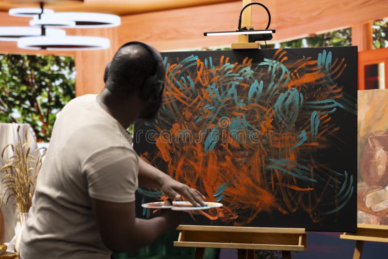 Painter applies watercolor paints to a canvas with his fingers royalty free stock images