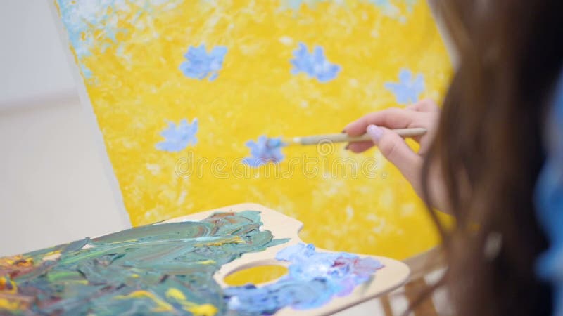 Painter hands blending cold colors on the palette..