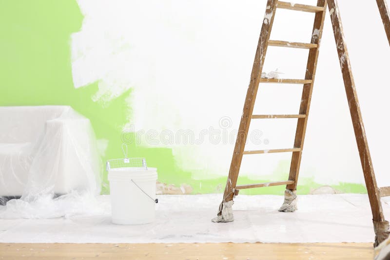 painter house concept, wooden ladder, bucket, and white and green color wall