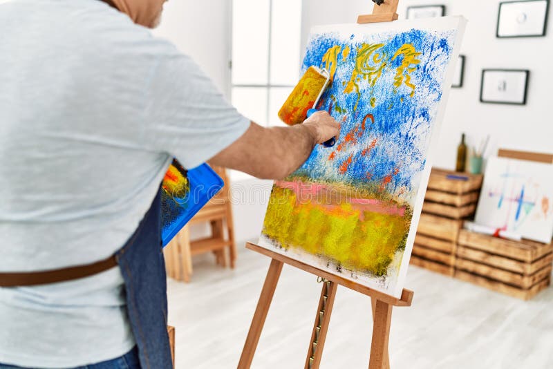 Painter Man Painting Using Paint Roller at Art Studio Stock Photo