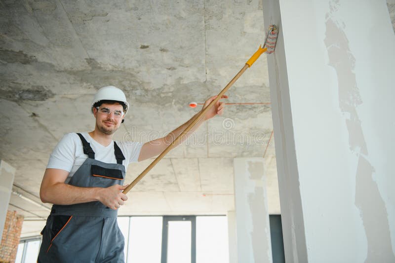 Painter man painting the wall, with paint roller stock photo