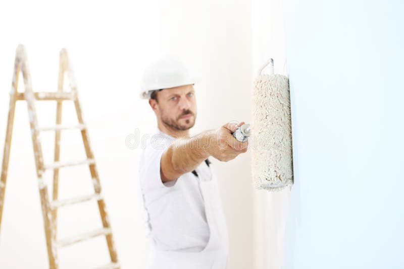 Painter man at work with a paint roller, wall painting stock photos Painter man at work with a paint roller, wall painting stock photos