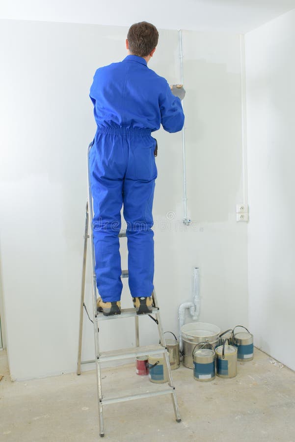 Painter painting the wall stock image. Image of salary 128019107