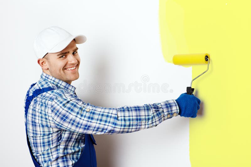 Feliz joven masculino pintor la pintura muro.