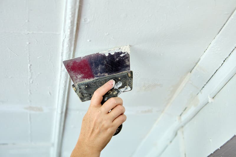 Using putty knife when finishing ceiling. Puttying surface with spatula and putty. Using putty knife when finishing ceiling. Puttying surface with spatula and putty.