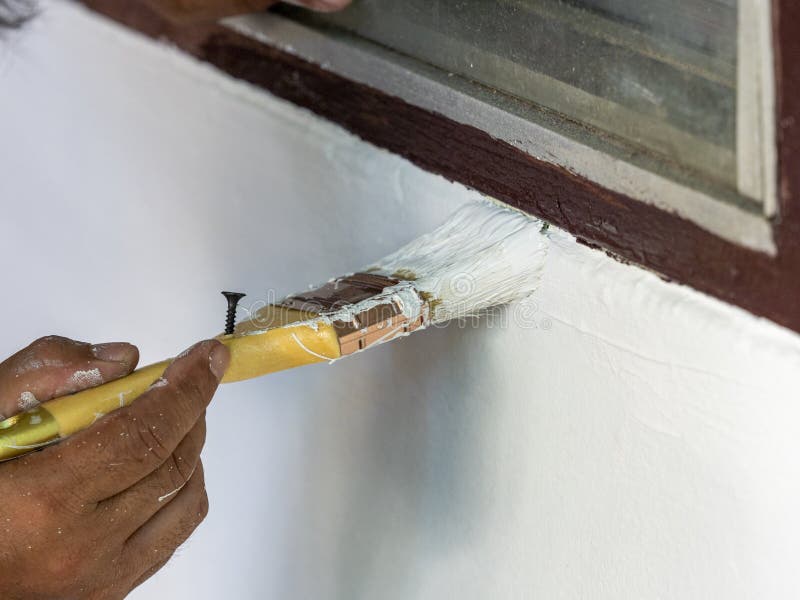 Painter Use Bush To Paint White Color on Wall Near Window Stock Image