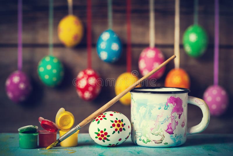 Painting Easter eggs and hanging colorful eggs on rustic wooden background. Painting Easter eggs and hanging colorful eggs on rustic wooden background