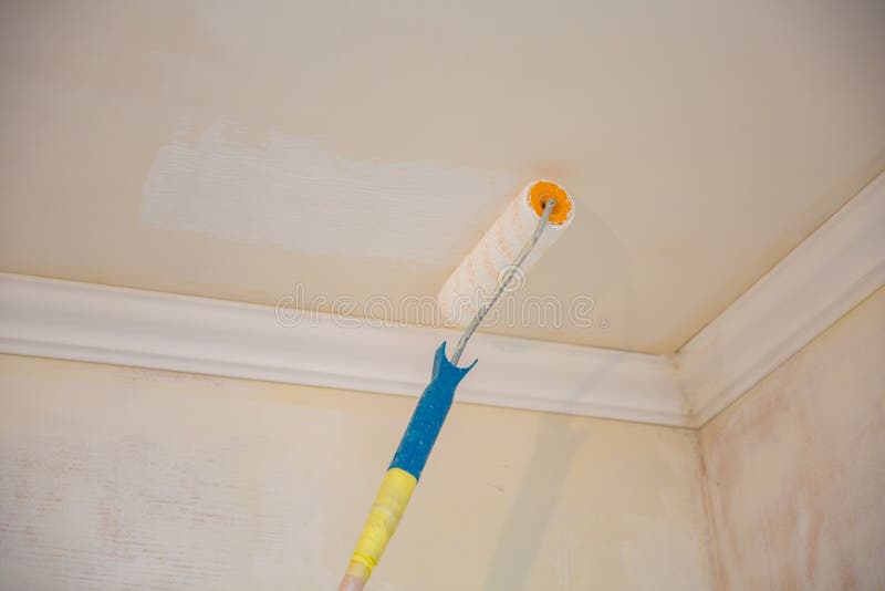 Painting A Gypsum Plaster Ceiling With Paint Roller Stock