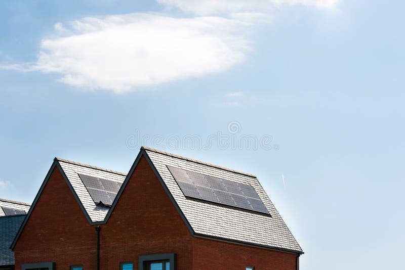 Painéis solares no telhado de casas novas em Inglaterra Reino Unido no dia ensolarado brilhante fotos de stock Painéis solares no telhado de casas novas em Inglaterra Reino Unido no dia ensolarado brilhante fotos de stock