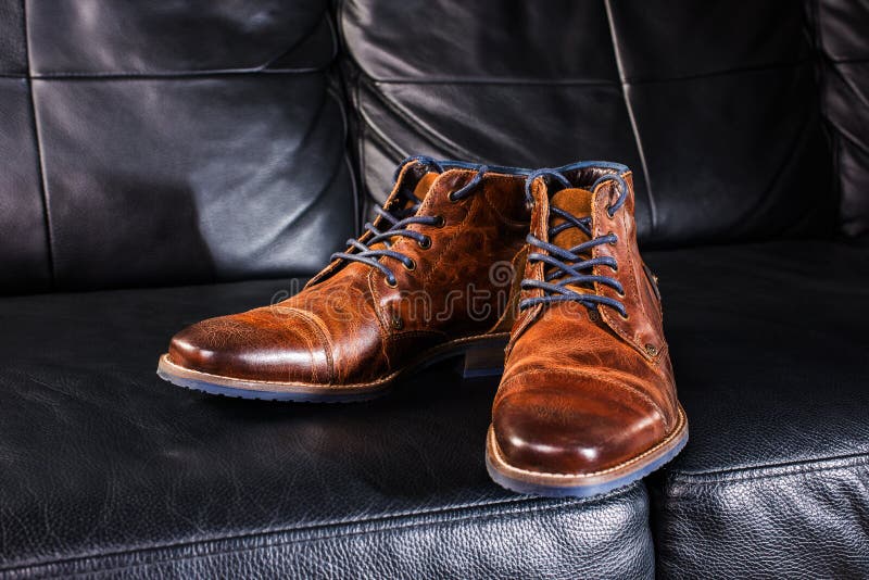 Brown Leather shoes displayed on black leather sofa