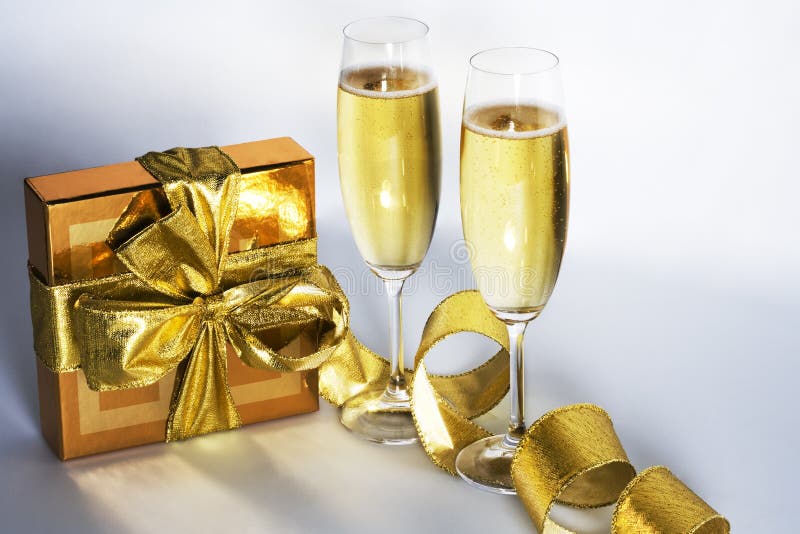 Pár šampaňské flétny a zlaté dárkové krabičce.