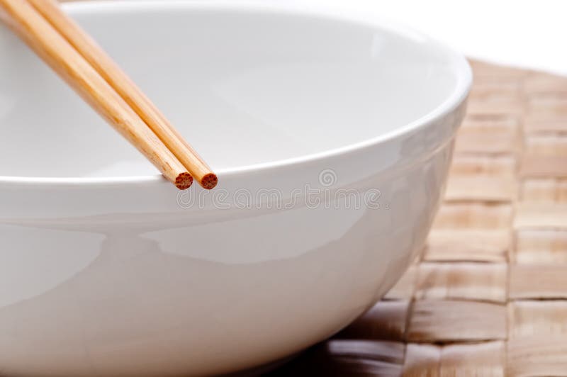 A pair of chopsticks on a white bowl