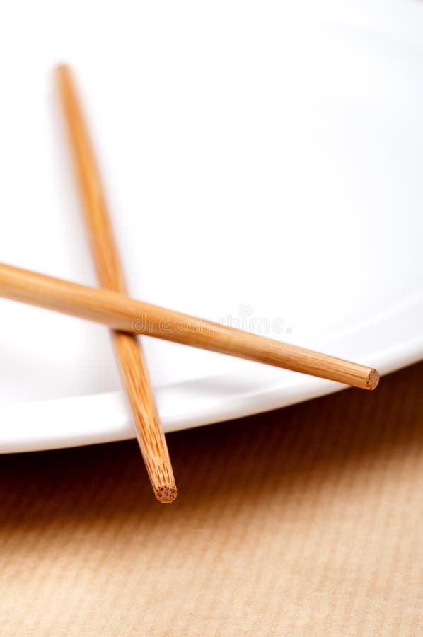 A pair of chopsticks on a white plate