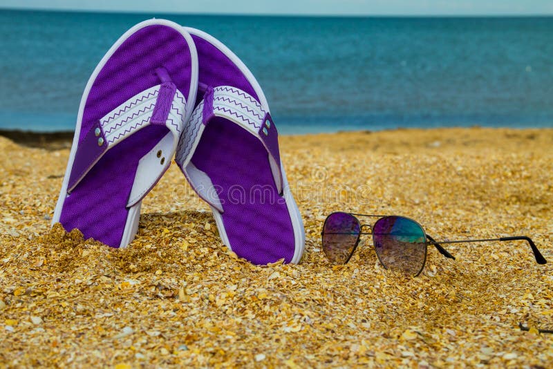 Pair of Flip Flops and Sunglasses on a Sandy Sea Beach Stock Image ...