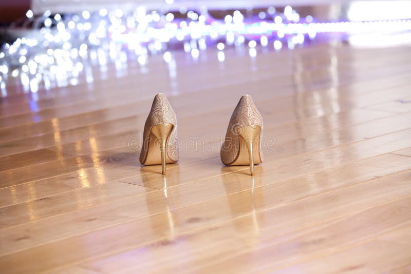 Pair of gold elegant women`s high-heeled shoes.