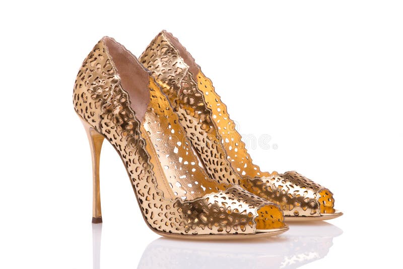 A pair of gold shoes on a white heel. Elegant holiday shoes