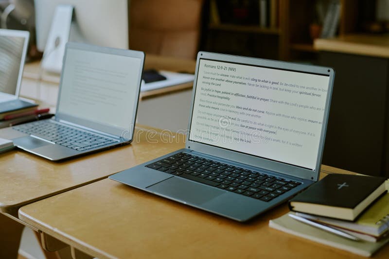 Pair of Laptops Displaying Text in Modern Workspace royalty free stock photo