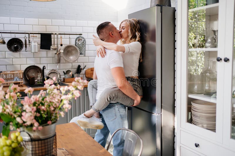 The Lovers Getting Hot In The Kitchen Pair of Lovers Kissing and Hugging in Kitchen Next To the Refrigerator