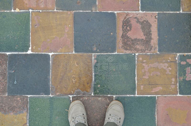 Pair of feet in canvas shoes on checkerboard sidewalk royalty free stock images Pair of feet in canvas shoes on checkerboard sidewalk royalty free stock images