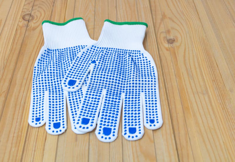 A pair of protective gloves for construction - on a wooden background. White with blue color. Pair working gloves stock images, royalty-free photos and pictures