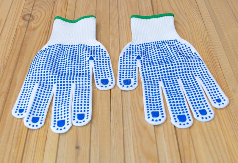 A pair of protective gloves for construction - on a wooden background. White with blue color. Pair working gloves stock images, royalty-free photos and pictures