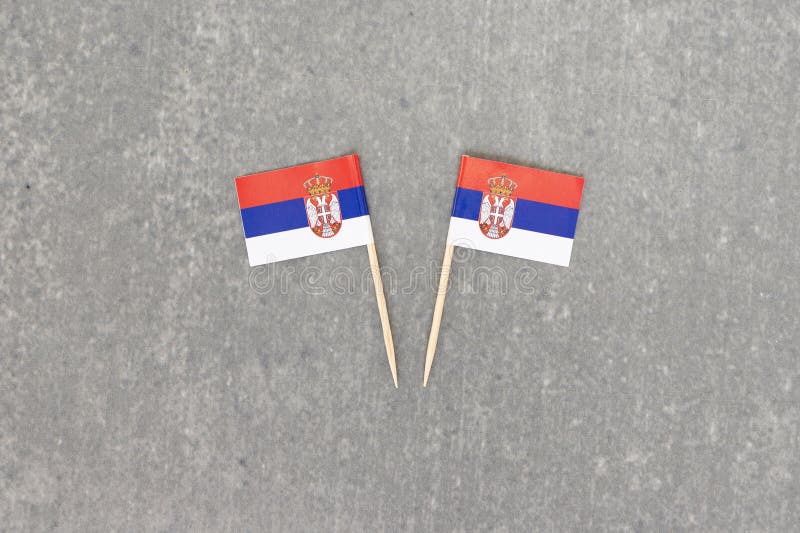 Pair of Serbian Flags on Toothpicks Against Stone Background royalty free stock photography