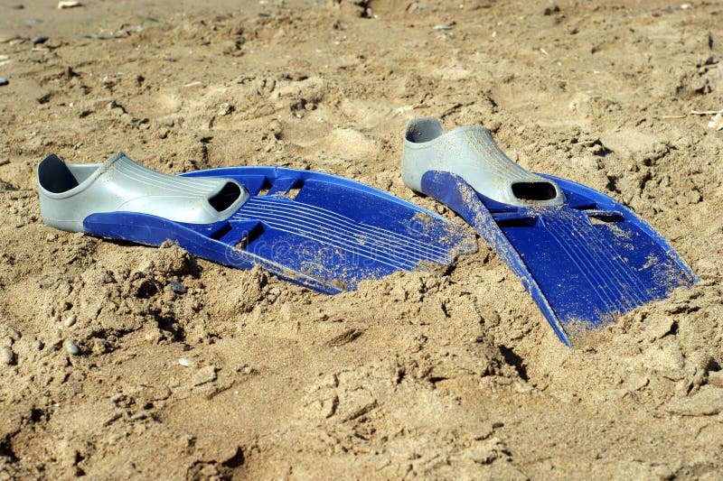 Pair of swimfins on the sand at sea