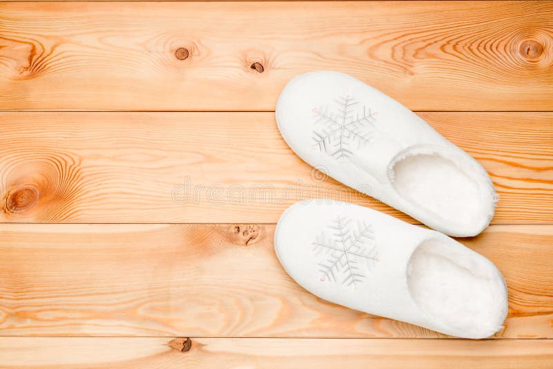 Pair of white warm slippers with snowflakes view from above on a