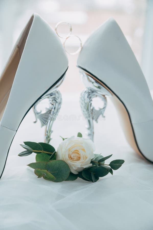 A pair of white wedding shoes with rings on a stool. royalty free stock photos A pair of white wedding shoes with rings on a stool. royalty free stock photos