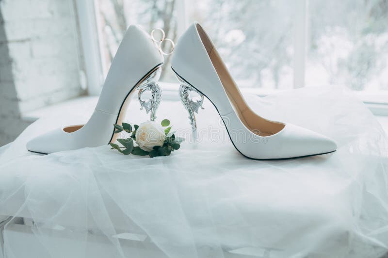 A pair of white wedding shoes with rings on a stool. royalty free stock photo A pair of white wedding shoes with rings on a stool. royalty free stock photo