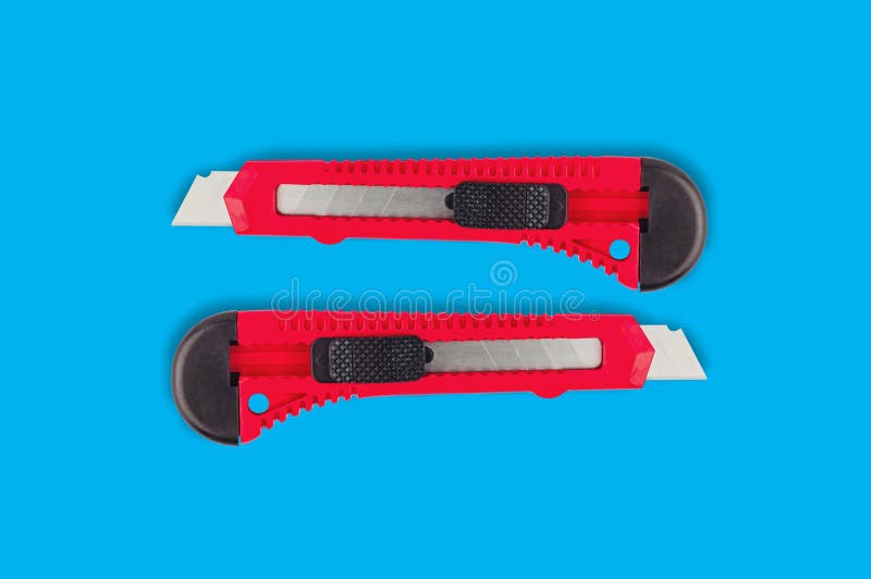 Paires de couteaux de papeterie avec la poignée en plastique rouge photos stock Paires de couteaux de papeterie avec la poignée en plastique rouge photos stock