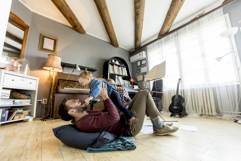 Pais novos que têm o divertimento com sua filha imagem de stock Pais novos que têm o divertimento com sua filha imagem de stock