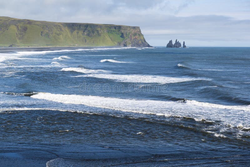 A paisagem atlântica da costa do ponto de opinião de Dyrholaey, das ondas e do Reynisdrangar balança, Islândia sul foto de stock A paisagem atlântica da costa do ponto de opinião de Dyrholaey, das ondas e do Reynisdrangar balança, Islândia sul foto de stock