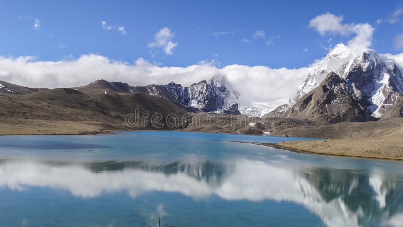 Beautiful landscape of vast sky mountain and lake with reflection of cloud in clean greenish water in nature with wonderful panoromic view. Beautiful landscape of vast sky mountain and lake with reflection of cloud in clean greenish water in nature with wonderful panoromic view