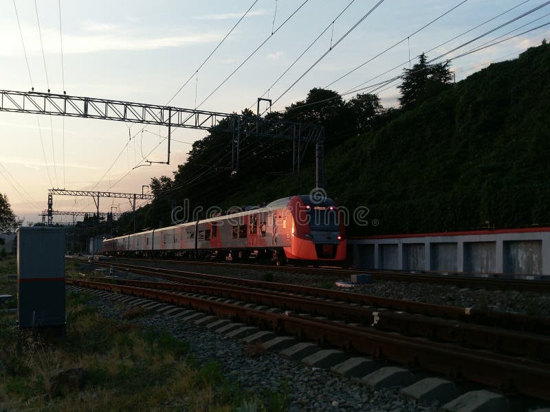 Paisagem da noite com um trem e a luz solar do por do sol foto de stock Paisagem da noite com um trem e a luz solar do por do sol foto de stock